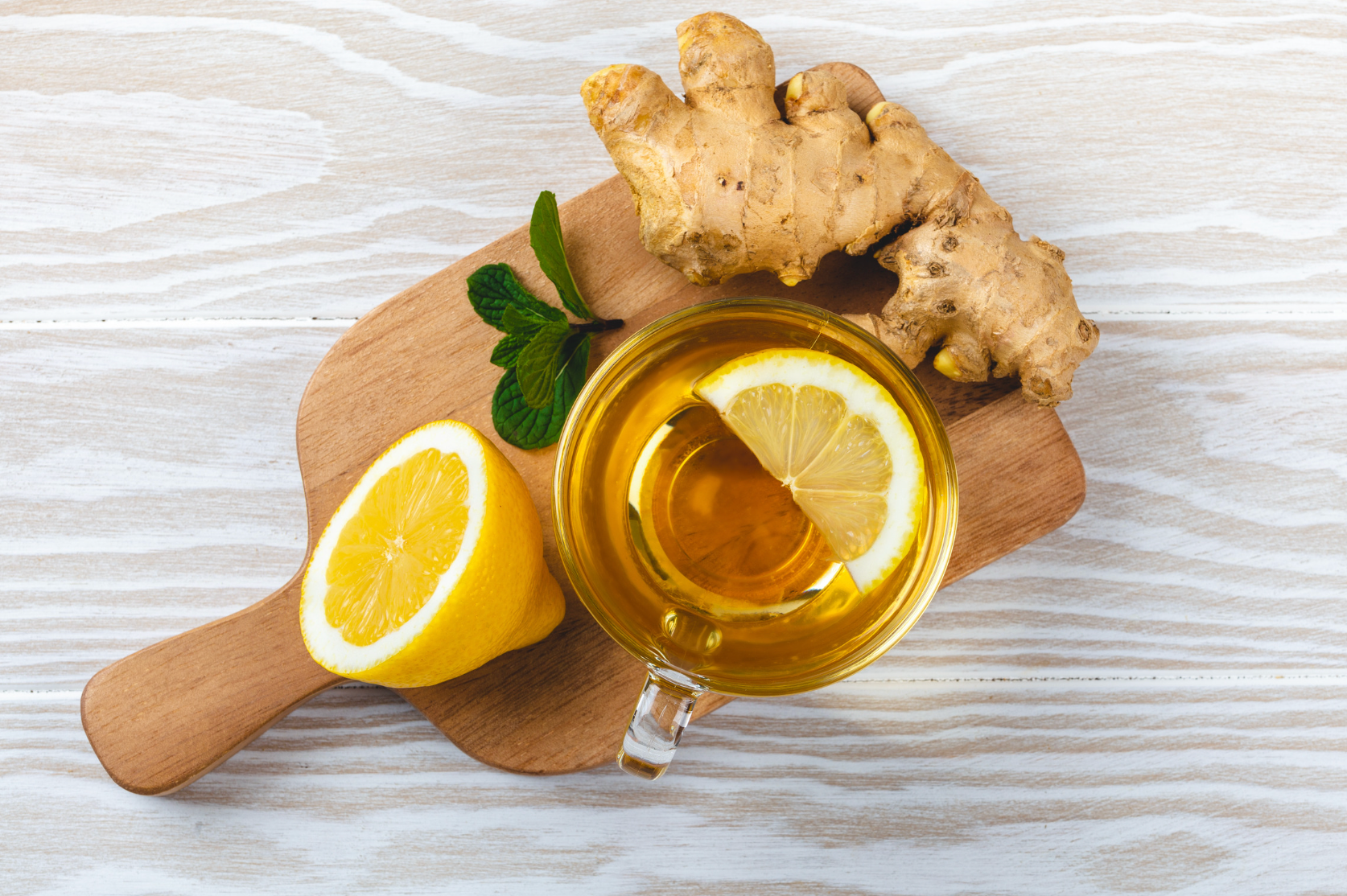 A vibrant cup of citrus tea featuring orange, lemon, and lime slices beautifully arranged around a clear glass.
